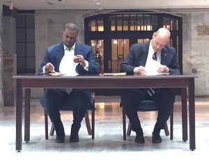 Kasim-Reed-signs-new-americans-deal