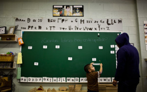 Guillermina Sandoval, 5, places his name tag on the chalk board at the Belmont-Cragin Early Childhood Center. Photo by Jonathan Gibby