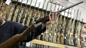 FILE--A salesman holds up a rifle at a Ottawa hunting store,  Tuesday May 16, 2006. Newly disclosed documents indicate the Tory government kept an important report on the long-gun registry under wraps until after a crucial vote in the House of Commons. (JONATHAN HAYWARD/CP)