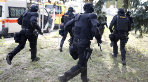 Hungarian riot policemen run as they are deployed at the border crossing with Serbia in Roszke, Hungary September 16, 2015. Hungarian riot police, backed by water cannon and armoured vehicles, moved into position at a border crossing on Wednesday where migrants were demanding they be allowed to cross from Serbia, a U.N. official at the scene told Reuters. REUTERS/Dado Ruvic  - RTS1DXN