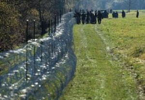Slovenian soldiers work on a wire fence in the village of Veliki Obrez, Slovenia, November 11, 2015. REUTERS/Antonio Bronic